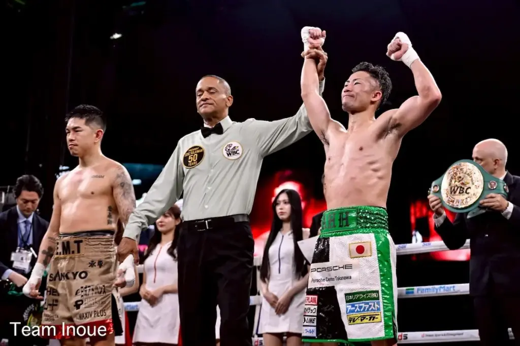 Takuma Inoue has his arm raised in victory against Kazuto Ioka