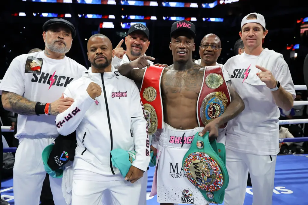 O'Shaquie Foster with belts and team after beating Emanuel Navarrete