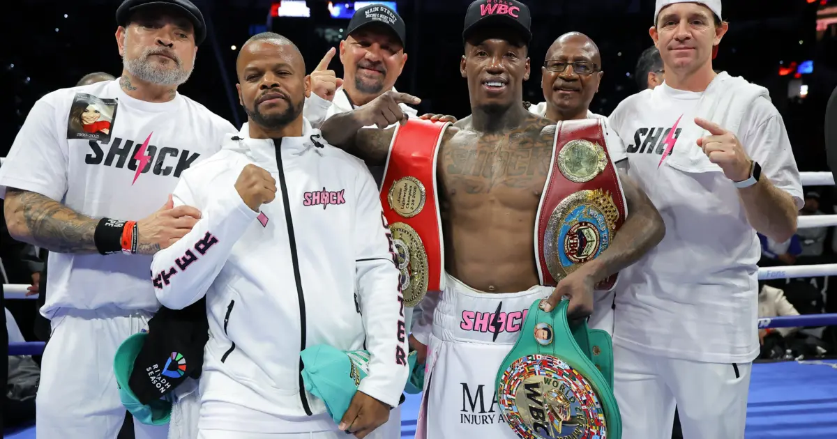 O'Shaquie Foster with belts and team after beating Emanuel Navarrete